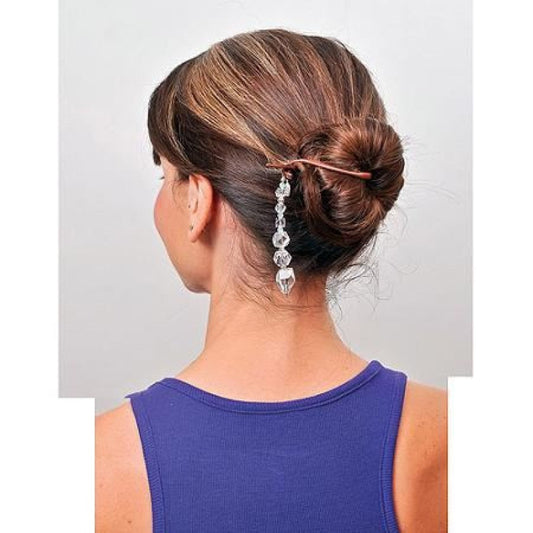 Woman with a stylish hair bun accessory on a plain background